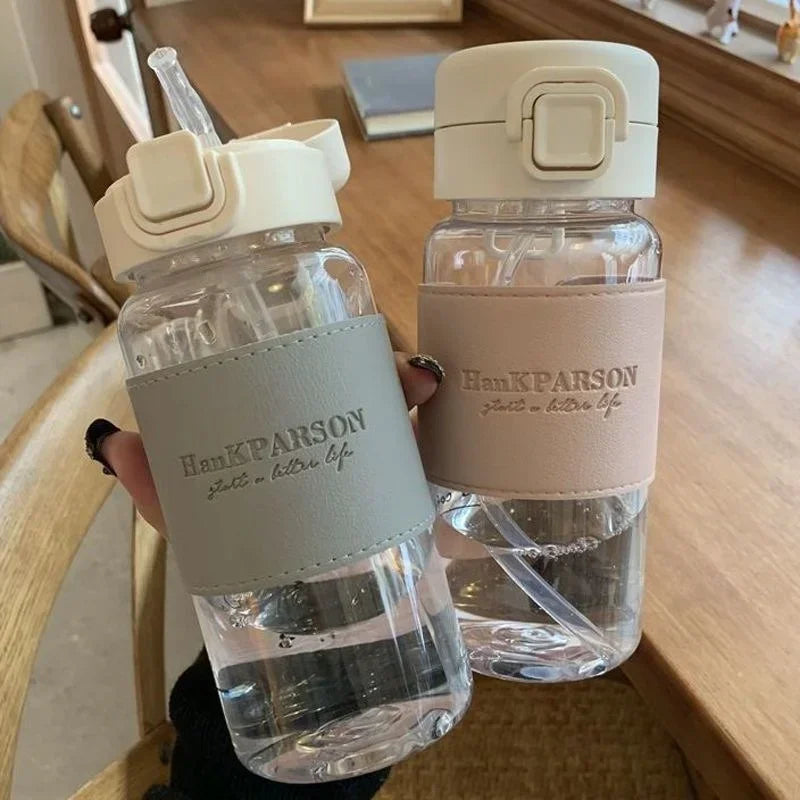 Two clear water bottles with beige caps and 'Han K. Parson' branding on a wooden surface.